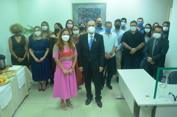 Foto da presidente do TJAC, desembargadora Waldirene Cordeiro ao lado do vice-presidente, desembargador Roberto Barros, de pé à frente da equipe de servidores da Diretoria de Pessoas do Tribunal de Justiça