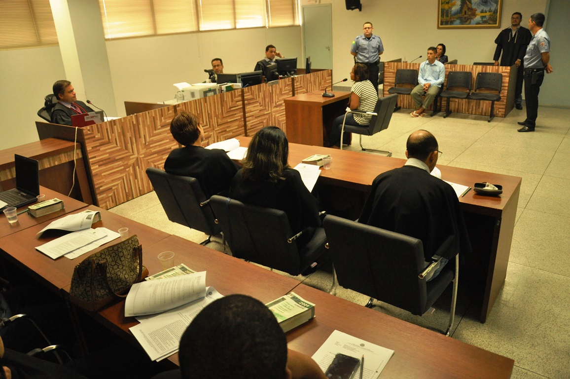 foto de jurados sentados em duas fileiras. Os jurados estão de costas e ao fundo ve-se uma pessoa sentada em uma cadeira de frente para bancada onde estão, juiz, escrivão e membro do Ministério Público