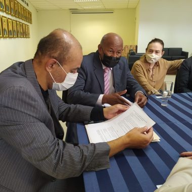 Três desembargadores. Dois homens e uma mulher. Um deles olha para o papel. 