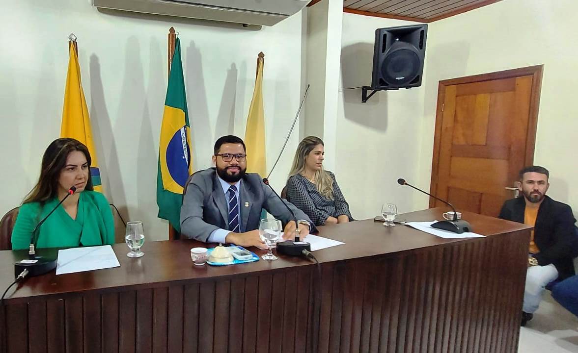 imagem do balcão da câmara de capixaba, mostrando a três pessoas sentadas atrás do balcão