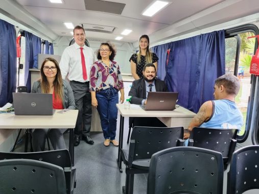 Imagem da equipe da Vepma sentada e de pé atrás das mesas atendendo uma pessoa