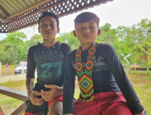 Adolescentes posam para fotografia. Um deles usa adorno com kenes característicos do povo Shanenawa