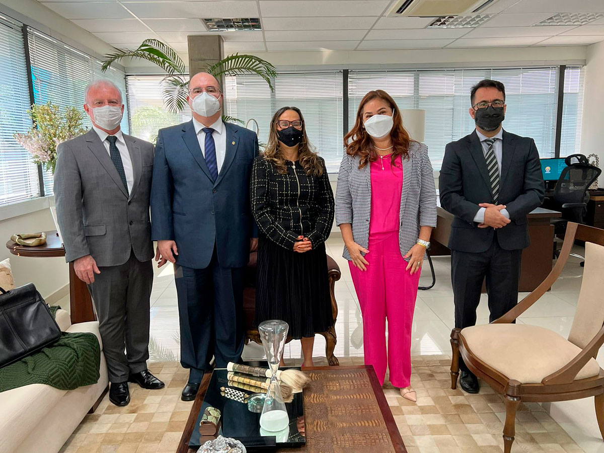 Foto das cinco pessoas em linha com máscaras olhando para foto